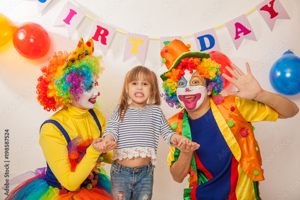 clown girl and clown boy at the birthday of a child. Party for children. Clowns and little girl show different emotions clown girl and clown boy at the birthday of a child. Party for children. Clowns and little girl show different emotions