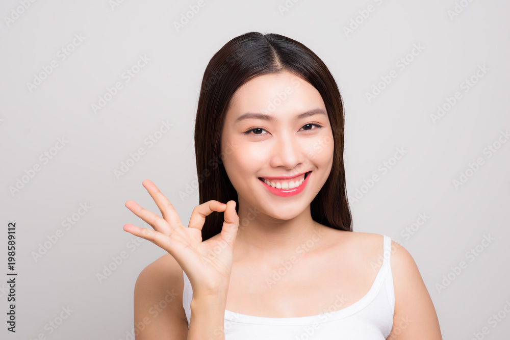 Portrait of a beautiful young woman with clean skin gesture ok sign. Portrait of a beautiful young woman with clean skin gesture ok sign.