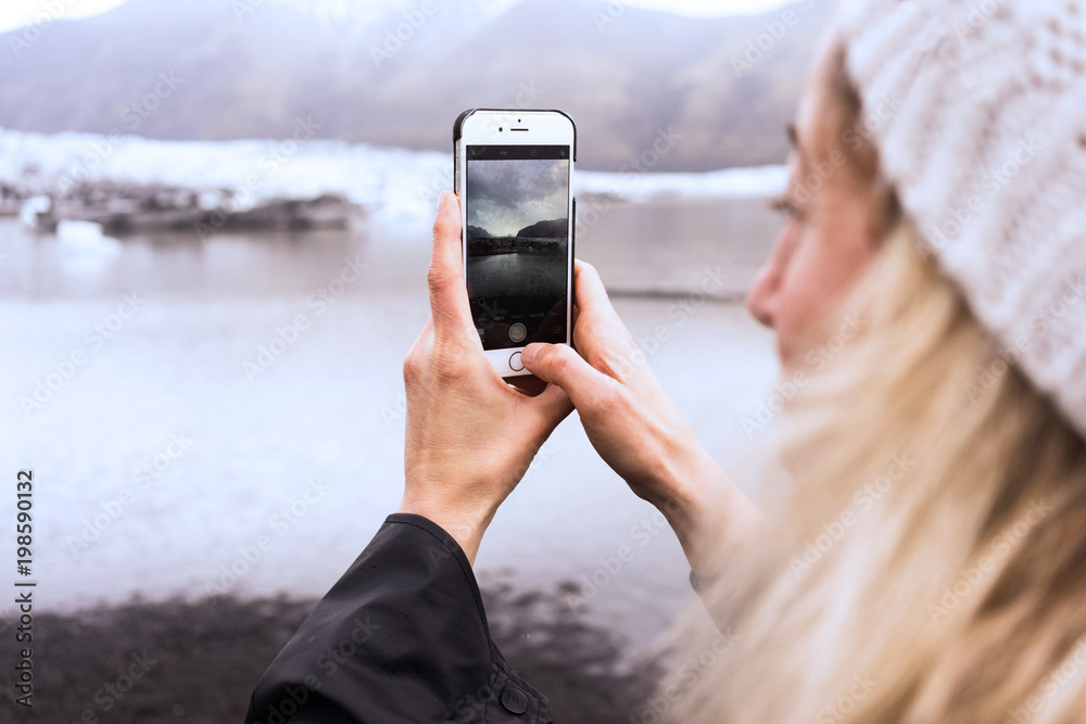 woman taking a picture of a scene on her phone