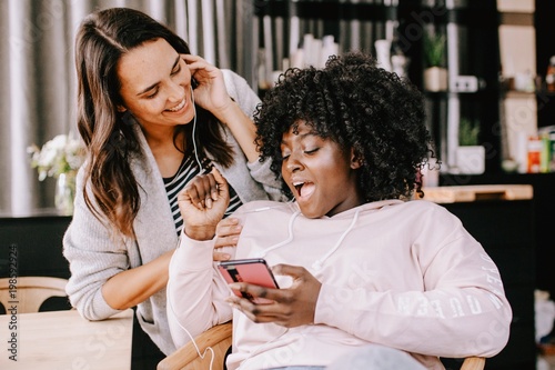 Freundinnen hören sich zusammen Musik an