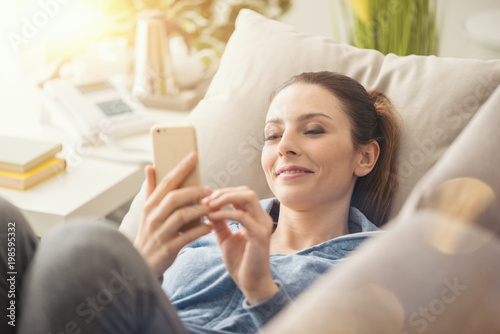 Woman on the couch using a smartphone