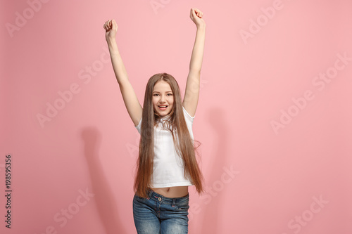 Happy success teen girl celebrating being a winner. Dynamic energetic image of female model