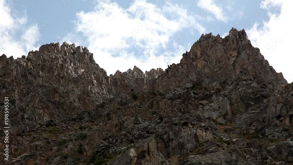 Clouds float on the sharp top of the mountain. Mountain range in the Altai Republic. Clouds float on the sharp top of the mountain. Mountain range in the Altai Republic.