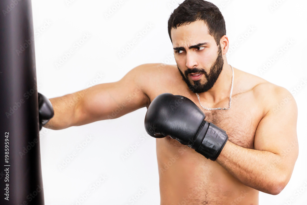 Muscular handsome topless boxer wears black gloves fights before white background