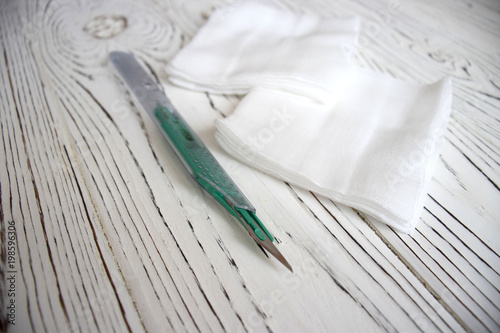 scalpel and gauze on a wooden table. copy space © Igorzvencom