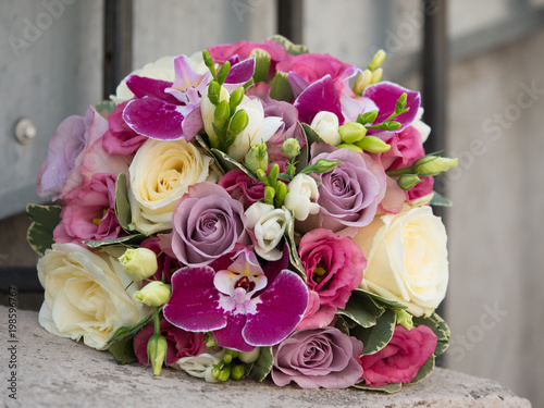 Beautiful bouquet of white and purple roses  violet orchids and freesias on a blurry background