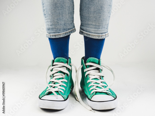 Stylish, bright, green sneakers and funny, happy socks on a white background. Sport, style, beauty, good mood