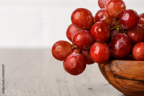 bunch of red grapes in a wooden Cup