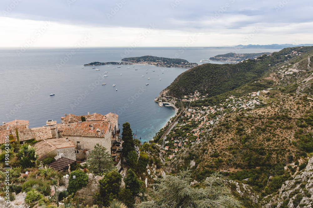 aerial view of european city located on hills by seashore on cloudy day, Eze, France