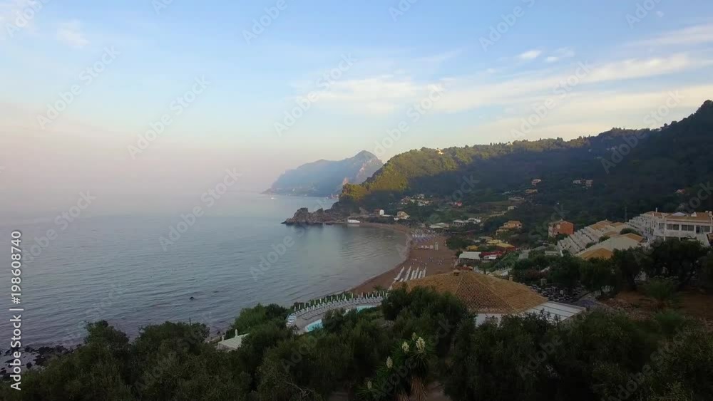 Aerial drone shot rising and panning from the Ionian Sea towards Pelekas Beach on Corfu Island Aerial drone shot rising and panning from the Ionian Sea towards Pelekas Beach on Corfu Island