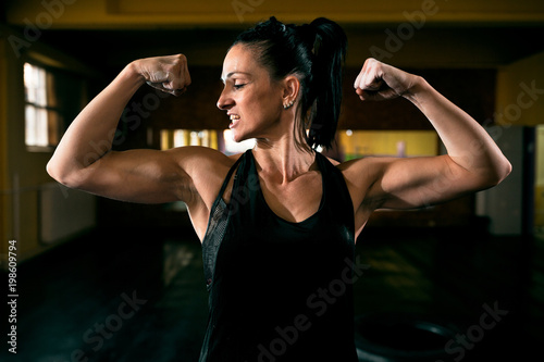 Muscular strong woman showing her body after workout