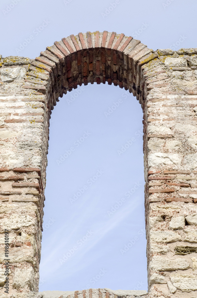 Sky through window arched stone and brick