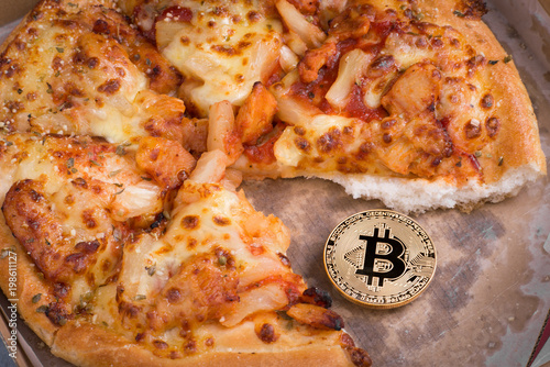 Bitcoin pizza day, physical golden bitcoin coin symbol and the pizza, future concept financial currency, crypto currency sign