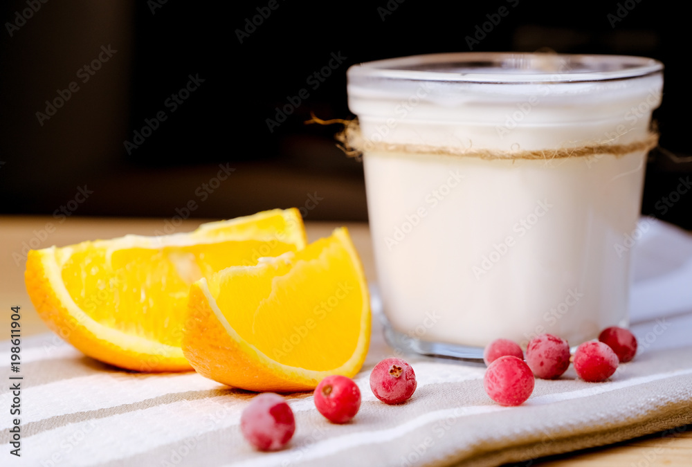 A jar of homemade yoghurt with fresh cranberries, fresh orange A jar of homemade yoghurt with fresh cranberries, fresh orange