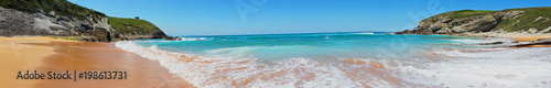 Beach with beautiful waves and blue sky, landscape. North Spain. Panoramic photo