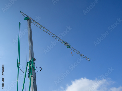 Fotografie small construction tower crane ,blue sky in background