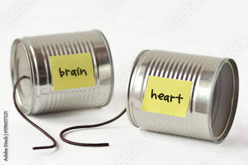 Tin cans phone with broken string and the words heart and brain written on paper note - Heart and brain broken connection concept photo