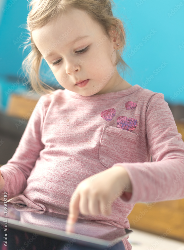 little girl is using a digital tablet little girl is using a digital tablet