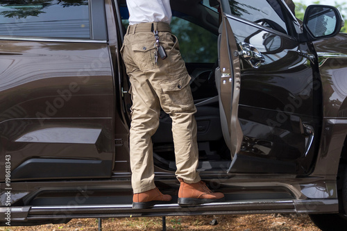Foto Man wearing cargo pants with suv car parking in the nature park