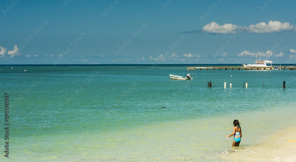 Puerto Rico Tropical Panoramic Beach Scene With Back of a Girl in Foreground and boats in the background 