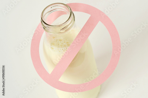 Glass bottle of milk with restriction sign - Lactose intolerance concept photo