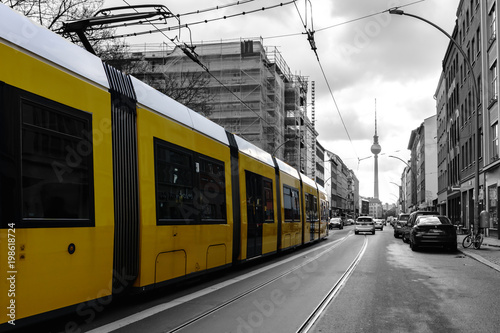 gele Straßenbahn in Berlin vor schwarz weißem Hintergrund