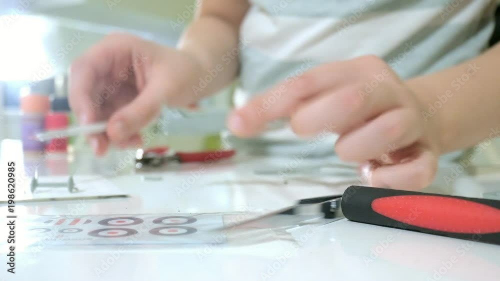 The boy creates a plastic model airplane, an exact copy, from the designer The boy creates a plastic model airplane, an exact copy, from the designer