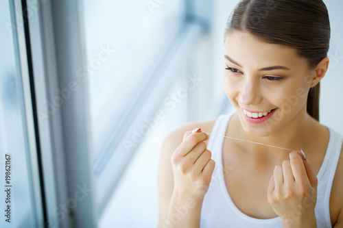 Dental Care. Woman With Beautiful Smile Using Floss For Teeth. High Resolution Image