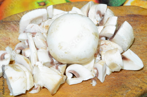  Sliced ​​and whole mushroom mushroom lie on the cutting board before cooking.