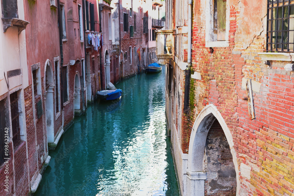 Venice, Italy. Canal and old vintage colorful facades with cracked stucco.