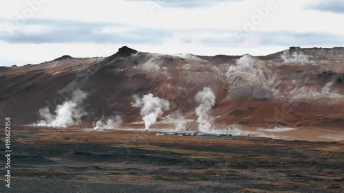 The landscape of geyser field with mountain range in the horizon. photo