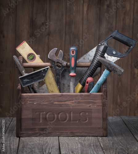 grungy old tools on a wooden background front view.