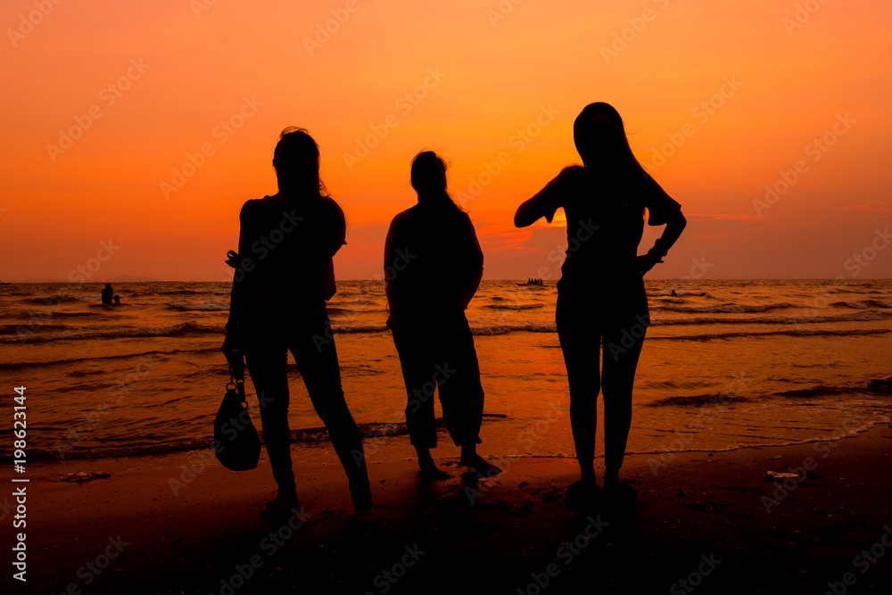 Woman is walking on the beach relaxing at sunset.