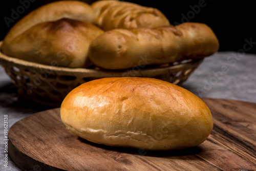 Fresh homemade burger bread buns on dark wood background photo