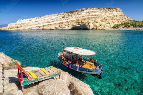 Clear sea and boat at Matala resort. Crete, Greece
