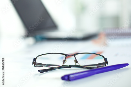 glasses on your desktop. work with drawings. business plan. stapler, magnifier