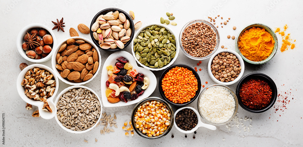 Composition with assortment of superfood products in bowls on gray background, top view