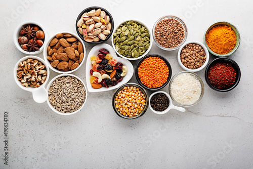 Composition with assortment of superfood products in bowls on gray background, top view