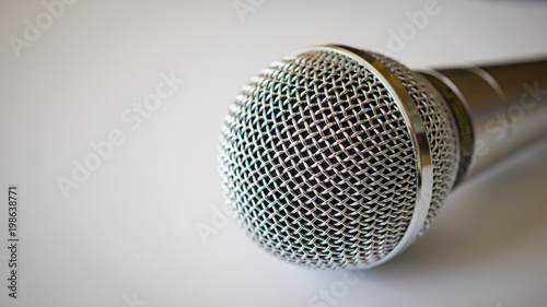 Silver handheld ballhead microphone on light background photo