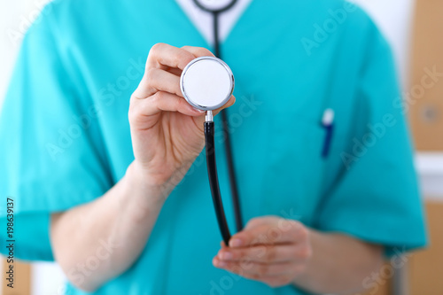 Female doctor holds stethoscope head closeup. Physicians ready to examine and help patient. Medical help and insurance in health care, best treatment and medicine concept