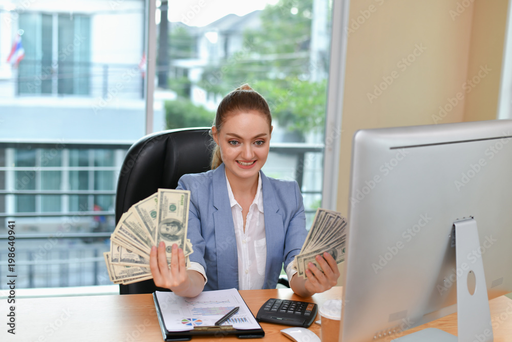 Business Concepts(Online Business). Young businesswoman holding money in hand. Young business people are happy with the income and money received. Young business women are saving money. Business Concepts(Online Business). Young businesswoman holding money in hand. Young business people are happy with the income and money received. Young business women are saving money.