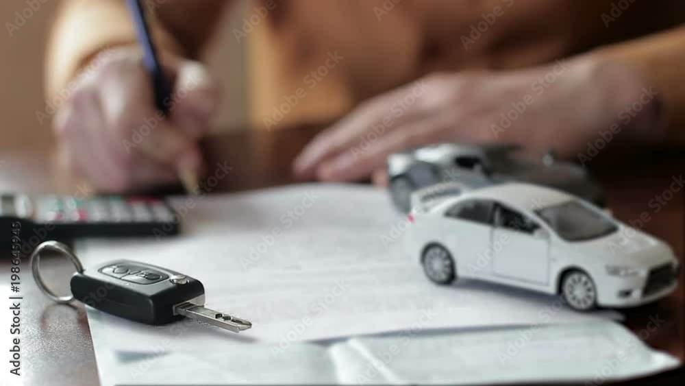 Male hands signing car insurance contract. concept: car insurance, car sales, garages, rental and alarm systems