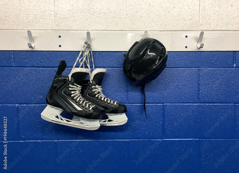 Hockey skates and helmet hanging on locker room with copy space Stock