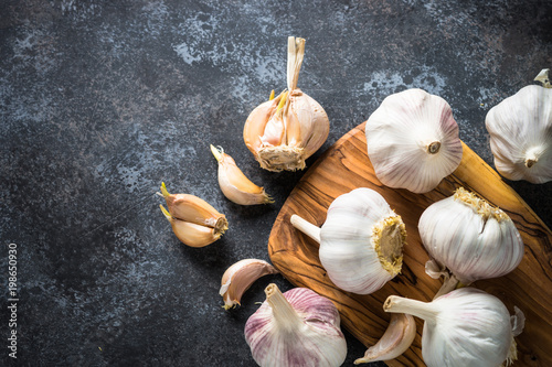 Garlic cloves on a dark stone background. 
