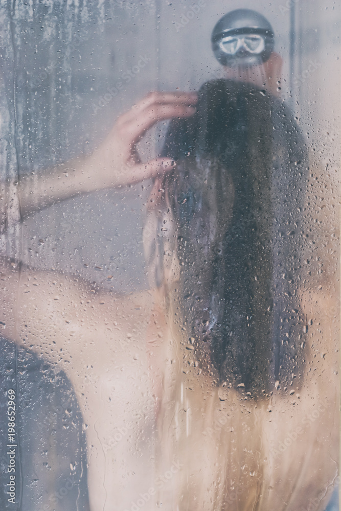 Frau wäscht in der Dusche ihre langen Haare