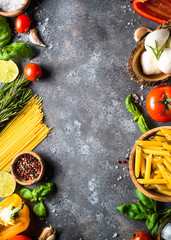 Italian food background. Pasta, herbs, vegetables on black top v