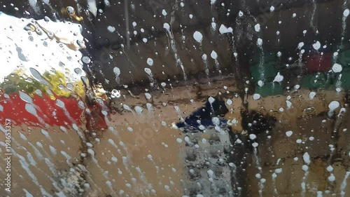 close up of front mirror surface of car cover with car wash soap in the car cleaning center.