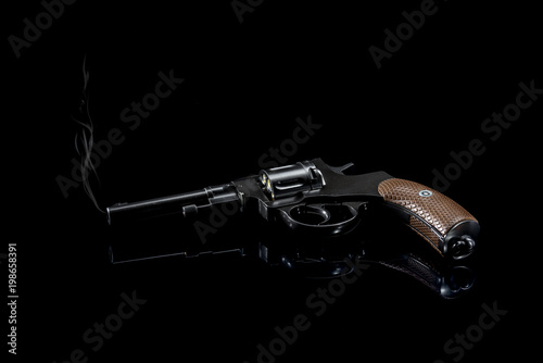 Revolver after a shot on a black background. photo