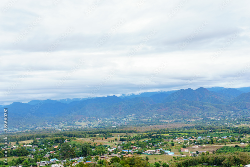 panorama landscape of field and local village with sky and cloud and layer of mountain background