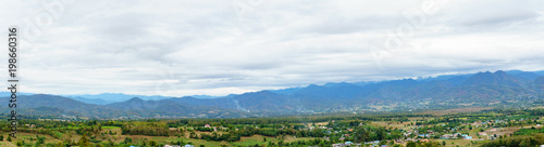 panorama landscape of field and local village with sky and cloud and layer of mountain background